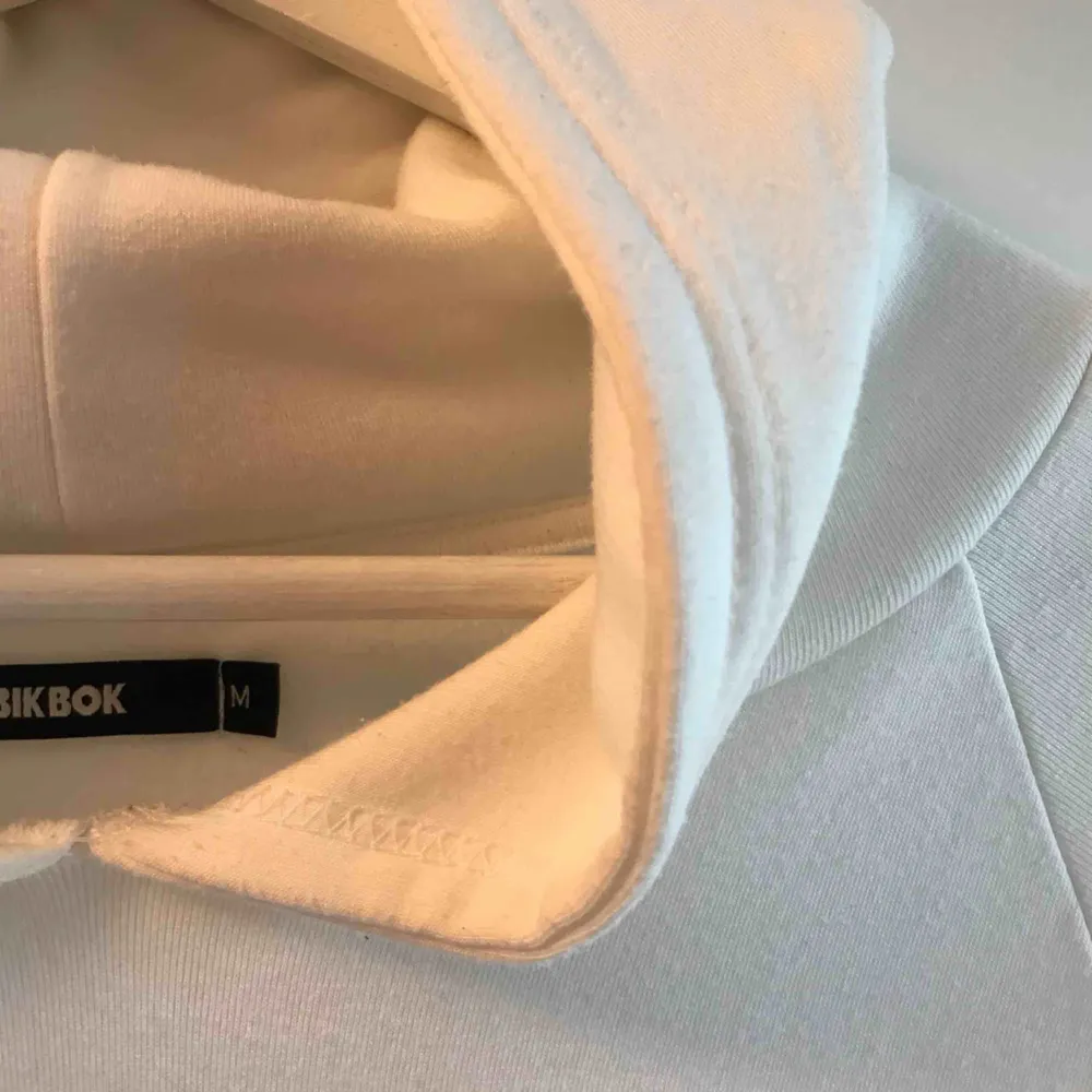 Vit croppad hoodie i supermjukt material från BikBok. Knappt använd så i bra skick. Den har blivit lite nopprig men det är inget man tänker på när man har den på sig då det är små ”noppror” (se sista bilden) . Hoodies.