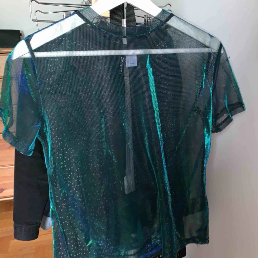 Halv oversized t shirt i glittrigt tyll. Blå/grön färg. Använd 1 gång. Köpare står för frakt . T-shirts.