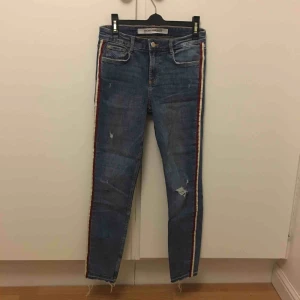  - Blåa skinnyjeans med vit och röd rand på sidan från Zara. Slitning på ena knät. Storlek 38 men jag tycker de sitter mer som 36 eller 34. 
