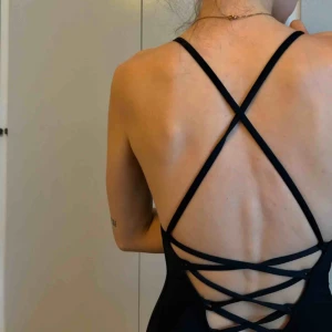  - Svart baddräkt med snörning i ryggen. Endast testad, aldrig använd. Nyskick! 