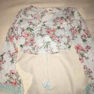  - Ljusblå, långärmad tröja med blommönster från hm. Det står att storleken är 40 men skulle nog säga att det passar bättre som 38.