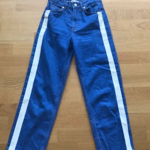 Zara jeans - Klarblå vida jeans från zara med vit rand på sidan och hög midja. På ena benet är den vita randen sliten (se bild 3) men det syns inte jättetydligt på. Frakt tillkommer. Hör av dig vid frågor 🥰