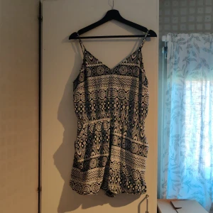 Mönstrad playsuit - Använd några gånger men är så gott som ny, inga fläckar och inget trasigt. Fickor i sidorna och resor i midjan. Justerbara axelband. Kan skickas, då betalar köparen frakten (priset kan dock diskuteras).