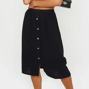 Kjol med knappar. - Svart kjol med knappar från PrettyLittleThing. Matrialet liknar linne. Storlek 32/Xs/S. Endast testad. Frakt ingår. Pris kan diskuteras!