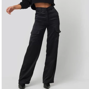 Satin pants NAKD - Superfina satin byxor från NAKD. Säljer pga för korta för mig som 180cm. Med fickor på låren. Inte mycket använda men lite små trådar sticker ut(se bild 3) och ena knappen på fickan är trasig, vilket inte syns. Nypris 500kr. Frakt tillkommer
