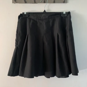 Tenniskjol American Apparel - Klassisk svart tenniskjol ifrån Amerikan Apparel. Märkt storlek L men skulle säga att det är M. I fint skick!