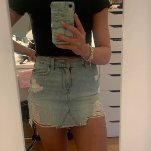 Ljusblå kjol från hollister - En superfin ljusblå kjol med slitningar från Hollister. Köpt för något år sedan men i fint skick. Dragkedjan är tyvärr sönder men det går lätt att fixa. Nypris 500kr