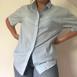 Ljusblå sommarskjorta - En ljusblå skjorta från HM (90-talet). Ganska oversized och passar allt från S till L