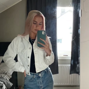 Vit jeansjacka  - En vit jeansjacka i kort modell. Den är från BikBok och har lite snygga slitningar på vissa ställen. Har dock en fläck vid högra fickan men den syns knappt :) Skriv för mer frågor 😊