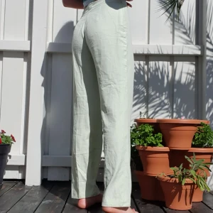 Pastellgröna utsvänga byxor - Ett par pastellpastellgröna utsvängda byxor men dragkedja på sidan. Köpta på second hand, använda få gånger av mig. De är insydda i midjan. Självklart tvättas och stryks alla kläder innan jag skickar iväg dem. Hör gärna av dig om du har frågor!🥰