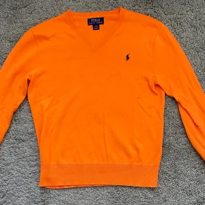 Orange v-ringad Ralph lauren tröja - Några få fläckar under märket men annars i bra skick. 