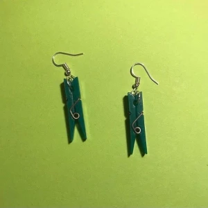 2 olika klädnypörhängen  - Ljusgrön klädnypa på ett guldiga örhängen. Mörkgröna klädnypor på ett par silvriga örhängen. Väldigt gulliga :) ett par örhängen kostar 30kr