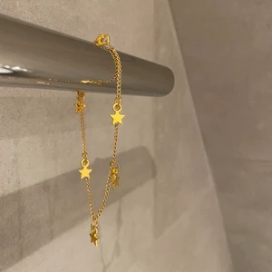 Armband, smycken  - X04. Jättefint armband i guld med stjärnor på. Glöm inte att 10% av vinsten går oavkortat till organisationen kvinna till kvinna. 