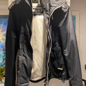 Vinterjacka från Superdry - En vinterjacka från Superdry med foderflis på insidan. Luva med päls och med dragkedja! Jacka är i jätte fint skick då den endast är använd ett flertal gånger. Säljes på grund av för liten. 
