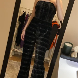 Pantsuit - En glittrig och randig pantsuit med resår för att plagget ska stanna uppe. Inga dragkedjor eftersom tyget är streching går det att kliva in i. 