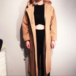  - Ankellång duffelkappa inköpt på Second Hand i storlek 40 (passar även 38) säljes för 250kr, frakt tillkommer. Kappans längd är 128cm från axel till fåll, modellen på bilden är 176cm lång. Betalning sker via swish.   Pris: 250kr Storlek: 40