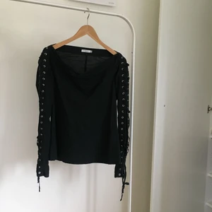  - Supercool, svart off shouldertopp med silverdetlajer och band i ärmarna. Från J Lindeberg
