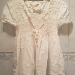  - Oss Milly blus med stretch runt bröstet. Super söt med korta ärmar. Pallar Medium eller Large. I deras egna storlek är den storlek 3.  