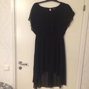  - Svart klänning med kortare underkjol och ”släpp” lite öppen rygg 