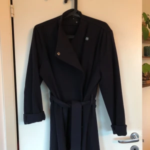  - Säljer min fina mörkblå (nästintill svart) ullkappa. Använd endast ett fåtal gånger. Tryckknappar hela vägen upp till halsen. Mycket klassisk stilren kappa, bilderna gör den inte riktigt rättvisa. Köparen betalar frakt ✨✨✨