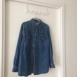 Jeansskjorta  - Mörkblå jeansskjorta. Sitter assnyggt på. Kan bäras öppen med T-shirt under. Är själv 38 och den passar bra på mig, inte för tajt. 150 inkl men öppen för förslag 💖 