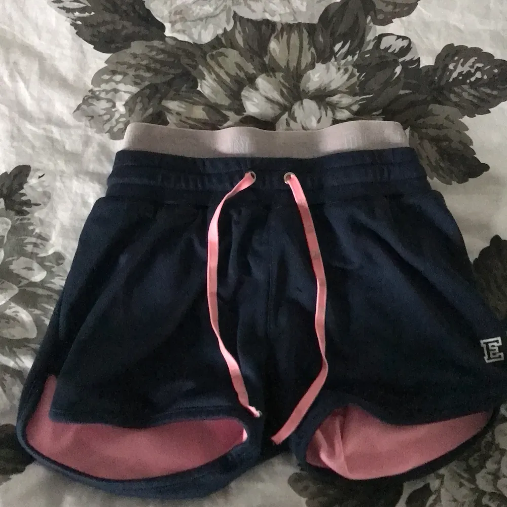 Ett par shorts i mörkblå och rosa, använda 1månad, ni står för frakten:). Shorts.