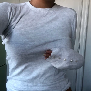 Vit/grå Zara knit tröja med pärlor - Tröja från zara, inte använd mycket. Grå vit fin färg, med pärlor vid ärmarna. Köpt för 200kr. Storlek S, är själv en M så den sitter lite tightare.