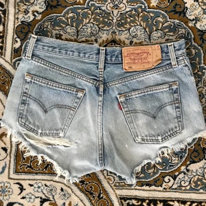 Vintage Levis 501 shorts - Reva under den vänstra bakfickan men annars i ett bra skick. Extremt bra passform dock sitter de lite för tight på mig rumpan än vad jag skulle vilja. Står W30 men skulle säga att de är mer W28. Köparen står för frakt. Kan gå ner i pris vid snabb affär