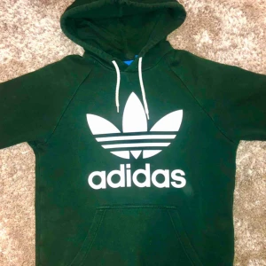  - Adidas originals hoodie i mörkgrönt, fläckfri (damm i luften på bilden).  Säljs billigt pga, väl använd