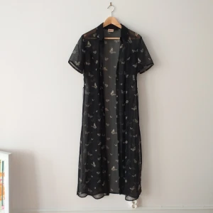 Kavajklänning - Skitfin klänning i genomskinligt material. Perfekt att ha över ett par jeans och linne som en typ av "kavaj". Kan knytas både fram och bak berode på vad man vill. Slits på båda sidorna. Använd få gånger, inköpt på humana. Står storlek 40, men skulle säga mer S/M