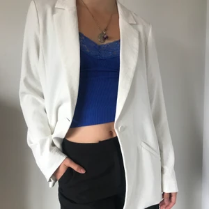 Gräddvit Kavaj stl 44 - Gräddvit kavaj från Stockholm LM. Använd endast en gång.  Stl 44 men skullle säga att den passar mindre storlekar för oversize känsla. Modellen på bilden har vanligtvis stl 36-38. Nypris runt 700kr. Kund betalar för frakt.