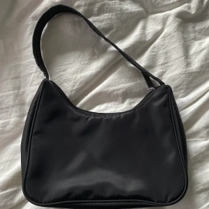 Väska från Monki - Svart väska från monki. Säljer pga den inte kommer till användning. Köparen står för frakten! 