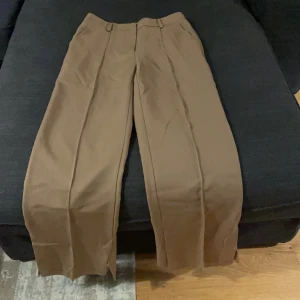 Beiga vida kostymbyxor - Beiga vida kostymbyxor med två slittar vid sorna av benslutet. Kan ej ta kort på då dom ej passar längre. Frakt ingår