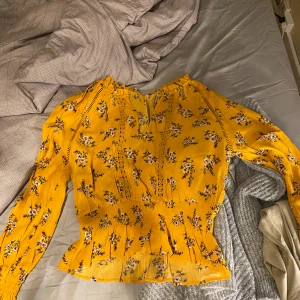 Blommig blus  - Väldigt fin blus i en gulfärg med blommor på, passar till så mycket