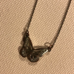 Halsband fjäril  - Ett halsband med en fjäril med små diamanter på vingarna. Säljer lite billigare eftersom den rostat lite 