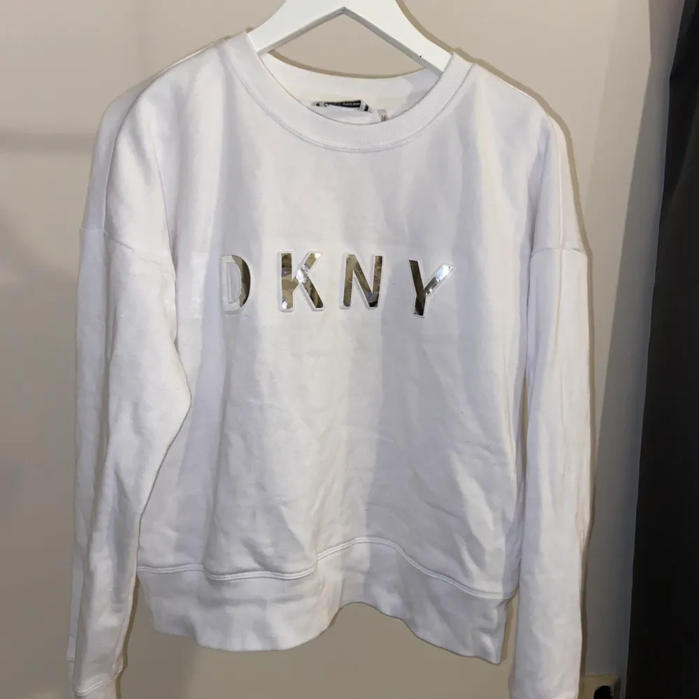 Vit tröja från DKNY, använd fåtal gånger då den inte riktigt passar i smaken. Mjukt och skönt material. Storlek S. Tröjor & Koftor.
