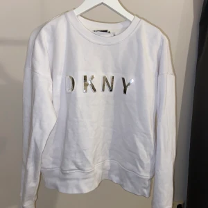 Vit tröja från DKNY - Vit tröja från DKNY, använd fåtal gånger då den inte riktigt passar i smaken. Mjukt och skönt material. Storlek S