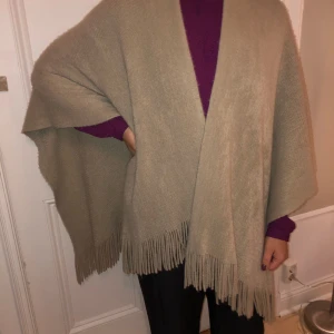 Poncho - Beige poncho med fransar nertill. ONE SIZE