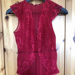  - En röd body i spets, fint skick knappt använd. köparen står för frakten 