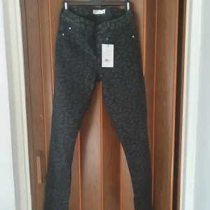 Jeans - Bekväma jeans i stretchigt material. Oavnända med lapparna kvar. Det är svarta leopardmönster på dom 