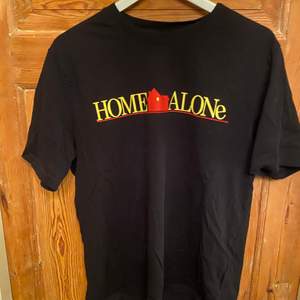 Svart T-shirt med home alone-tryck. Köparen står för frakt eller mötas i Sollentuna Centrum.