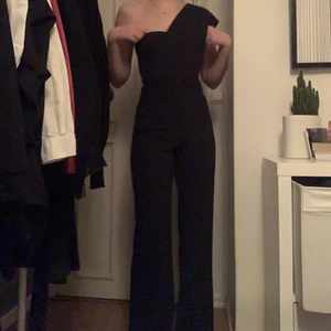 Byxdress - Marinblå byxdress, one shoulder med långa vida ben. Riktigt fin byxdress men kommer aldrig till användning tyvärr. Passar strl XS-S. Helt i ny skick