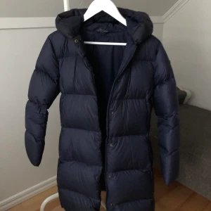 Ralph Lauren dunjacka - Säljer min älskade blåa Polo Ralph Lauren dunjacka. Den är i juniorstorlek XL vilket motsvarar en Xs eller S. Jackan är lång, väldigt varm och inköpt på NK för några år sedan för runt 2000 kr. Den har inga defekter alls och jag har fått många fina komplimanger när jag burit den. Säljer den för 400 kr eller högst budande. Kan mötas upp i Stockholm