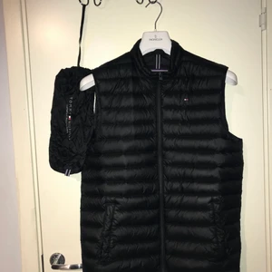 Tommy Hilfiger väst  - Hej! Säljer nu min fina dunväst som passar perfekt till våren. Medföljer även en Tommy Hilfiger påse.           Västen är storlek S.                                                            Sparsamt använd. Köpt i NK Stockholm.                                        Nypris: 2499 kr                                                                    Mitt pris: 649kr            