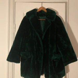 Grön pälsjacka vintage  - Vintage Grön/smaragd pälsjacka (ej äkta päls)! Suuuperfin färg och varm! lite trasig i silket i ena armhålan men går nog lätt att sy :) storlek S-L beroende på hur man vill att den ska sitta 