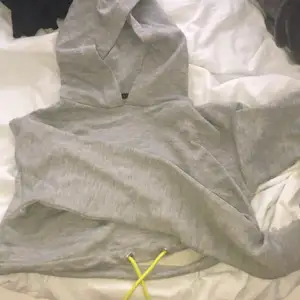 Cropped grå hoodie med snöre i midjan. Oanvänd