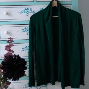 En grön kofta från Cortefiel, storlek S.  - En grön fantastsisk kofta. Väldigt mjuk och skön. Dessutom väldigt elegant i färgen, formen och detaljerna. Som första utgångspris ligger den på 90 kr + frakt. Skriv gärna bud i kommentarsfältet. 