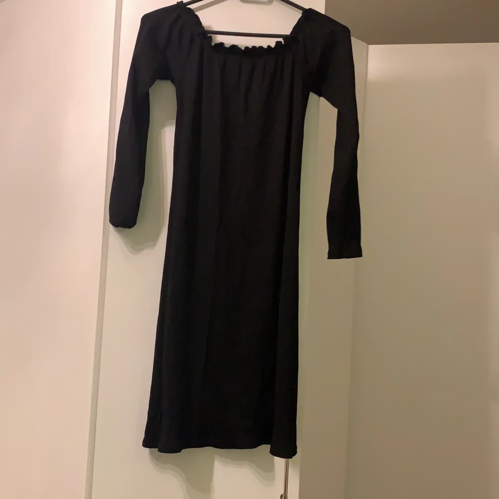 Oanvänd svart klänning, säljs för den är för liten för mig. Långärmad. Axelbandslös klänning med 3/4 armar. Klänningens längd sträcker sig precis ovanför knäna. . Klänningar.
