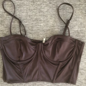 Brun topp - Säljer denna otroligt fina topp från Hm då den tyvärr är för liten. Storlek 40 men skulle säga mer att det är som en storlek 36. Jag har C-kupa och denna är för liten, så skulle säga att den passar A/B kupa. Högsta bud 140kr inkl frakt.