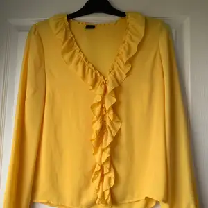 En väldigt fin gul blus från Gina tricot med volanger. Den är i väldigt fint skick! Använd ett fåtal gånger. 
